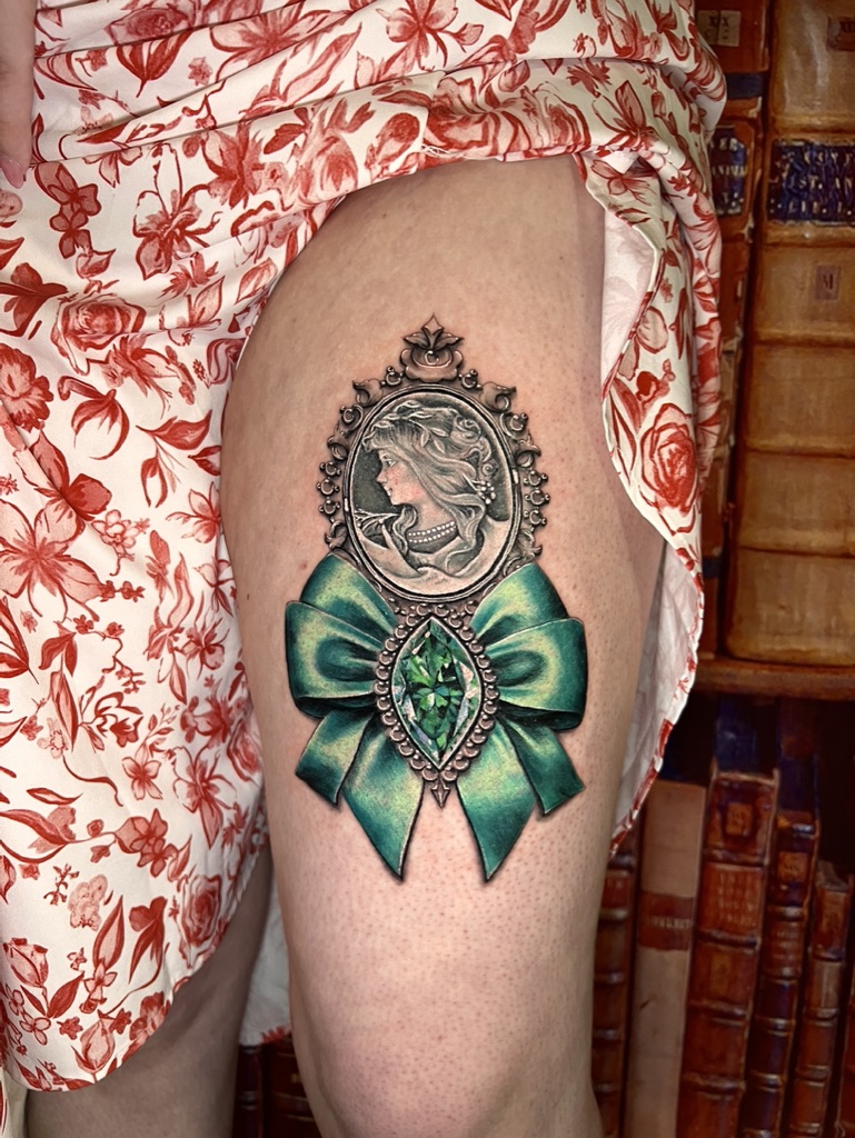Tattoo-Bijoux avec un camée de visage féminin, un noeud vert en satin et une pierre à facettes vertes en forme de marquise