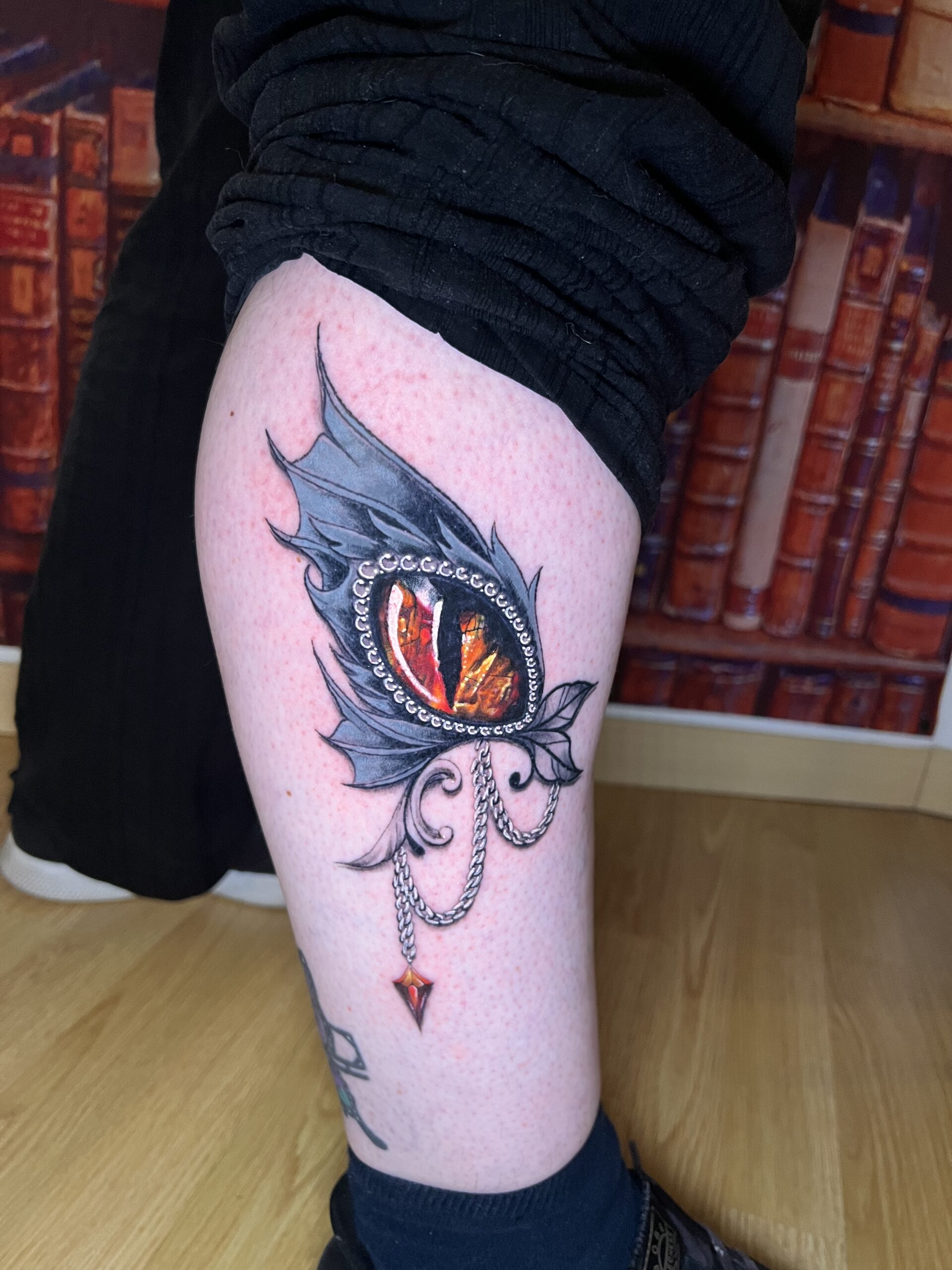 Tattoo-Bijoux avec un oeil de dragon intégré dans une aile grise